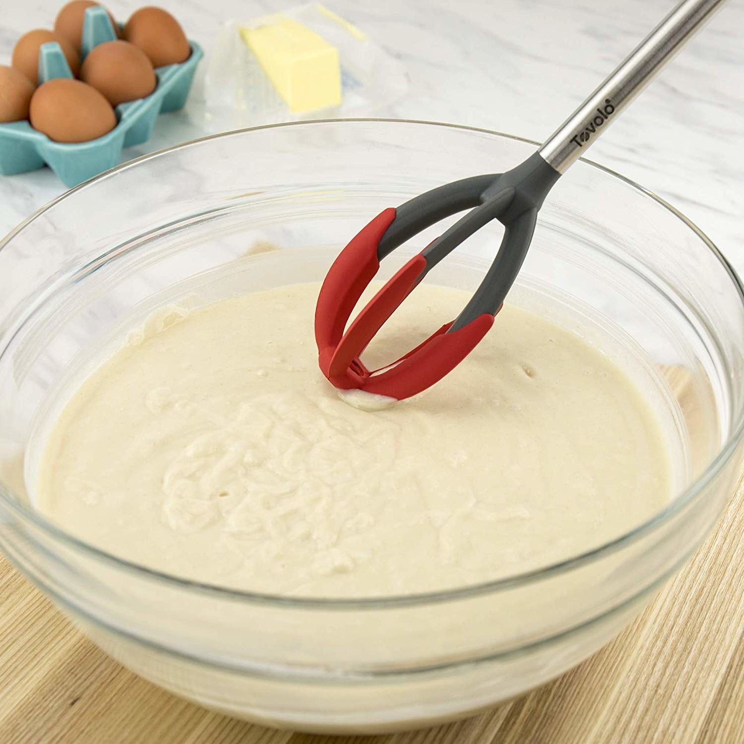 the whisk being used in a bowl of batter