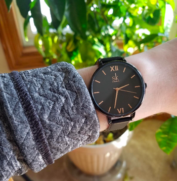 Reviewer wearing the watch in black with gold accents