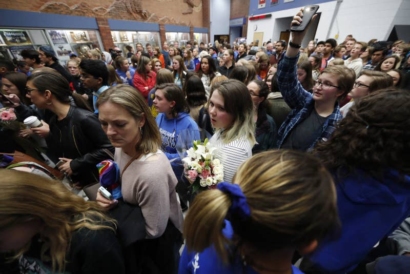 Students and others gather in the high school hallway after walking out of the vigil.