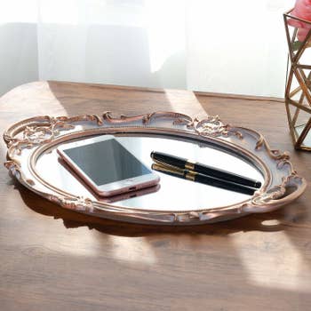 The mirror tray with a phone and a pen on it