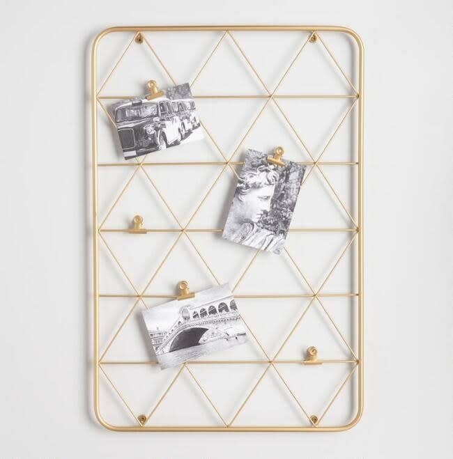 The frame with gold wire triangles with clips holding up three photos