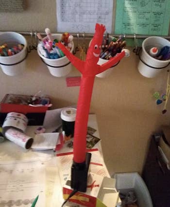 a reviewers tiny red inflatable tube man on their desk