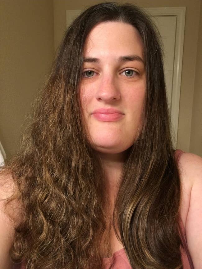 reviewer shows one side of their hair looking frizzy and wavy and the other half looking silky smooth and straight