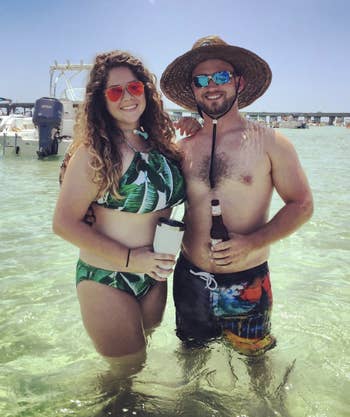 a reviewer wearing a high neck green leaf print bathing suit and matching bottoms