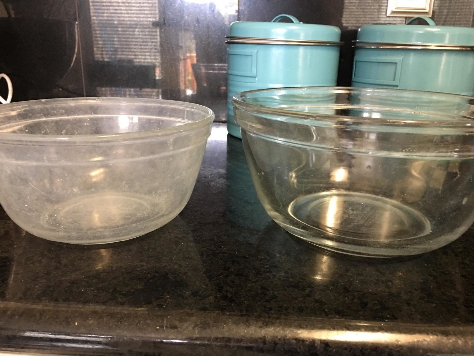Two glass mixing bowls: One cloudy and white because it was washed in hard water; the other perfectly clear because it was washed with the booster