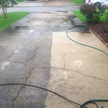 Reviewer image of a driveway half cleaned with the sun joe pressure washer; the left side is dark and dirty, and the right side is clean and beige