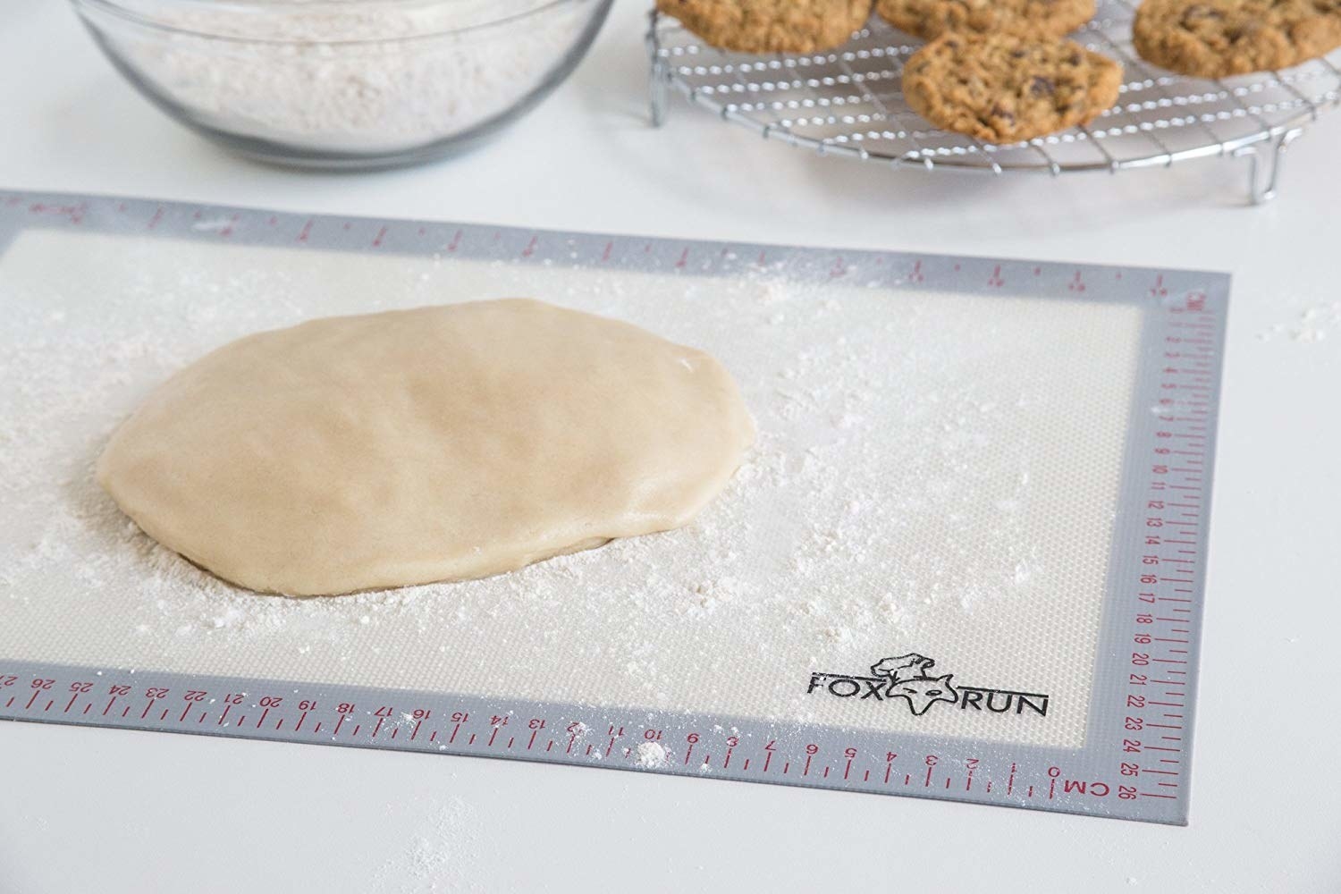 the baking mat with dough and flour, featuring measurements along the side
