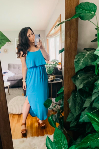 A reviewer wearing the dress in teal