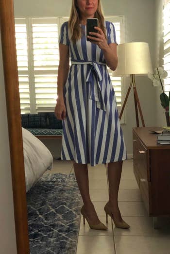 A reviewer wearing the short-sleeve dress with a tie waist in blue and white