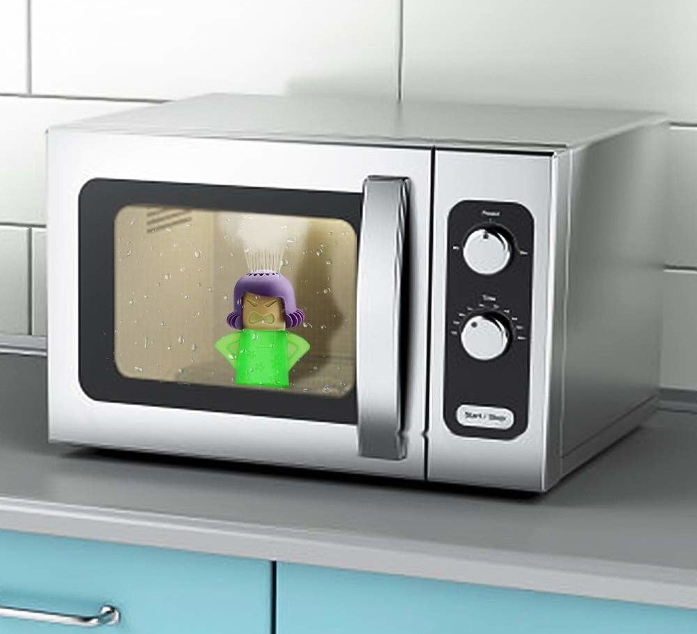 The microwave cleaner is actually a small bottle shaped like a woman&#x27;s shoulders and head. Her head has tiny holes where the cleaning concoction will spurt from to clean the microwave. It&#x27;s sitting inside of a microwave.