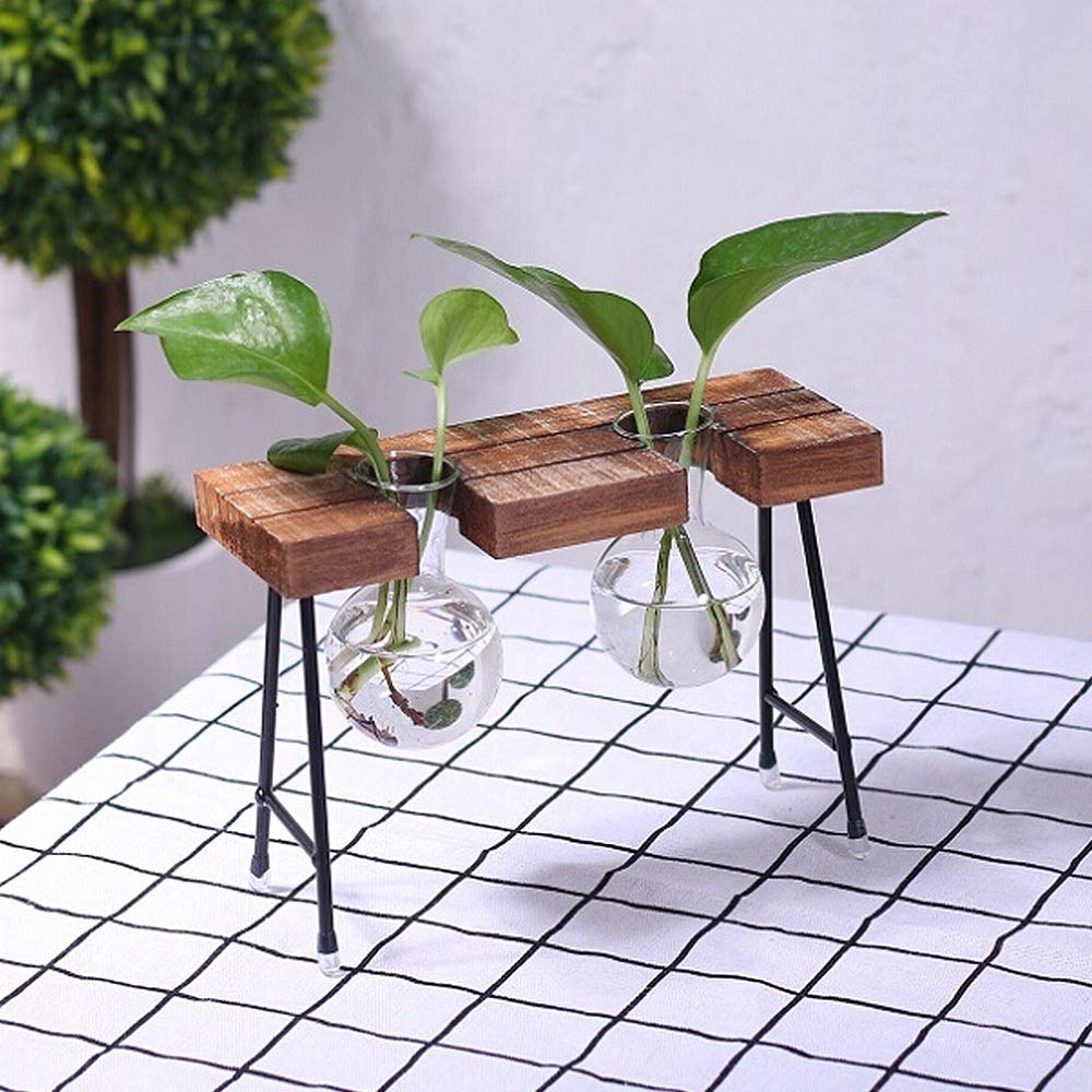 two round bud vases held upright with wooden shelf with thin metal legs 