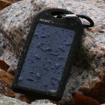 solar power bank with droplets of water on it and carabeener attached