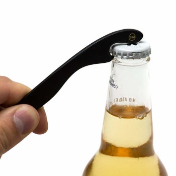 Person is opening a bottle of beer using the end of the glasses