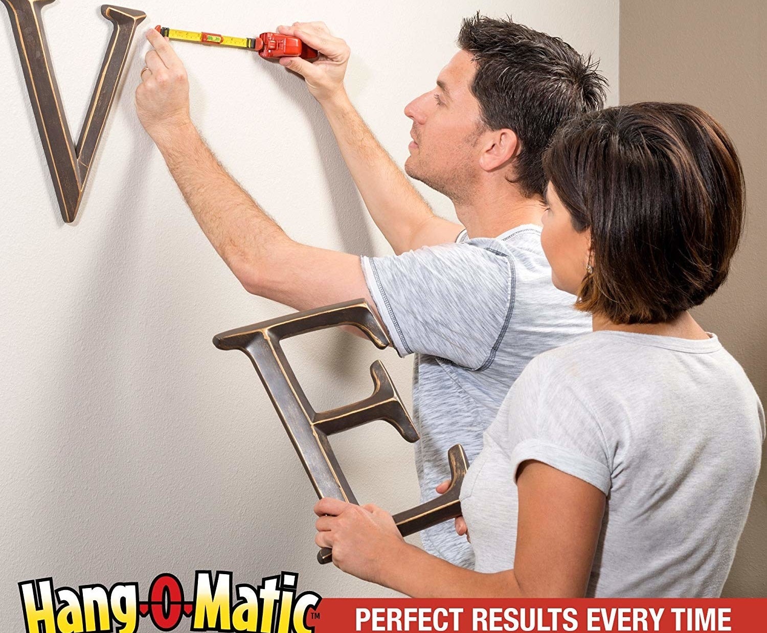 A person using the tool to hang a piece of wall art