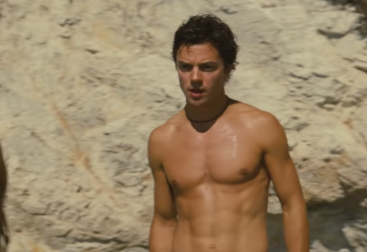 Shirtless Dominic Cooper from a beach scene