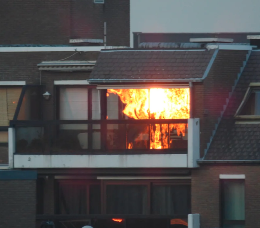 A bright flame looking light in a mirror outside an apartment building