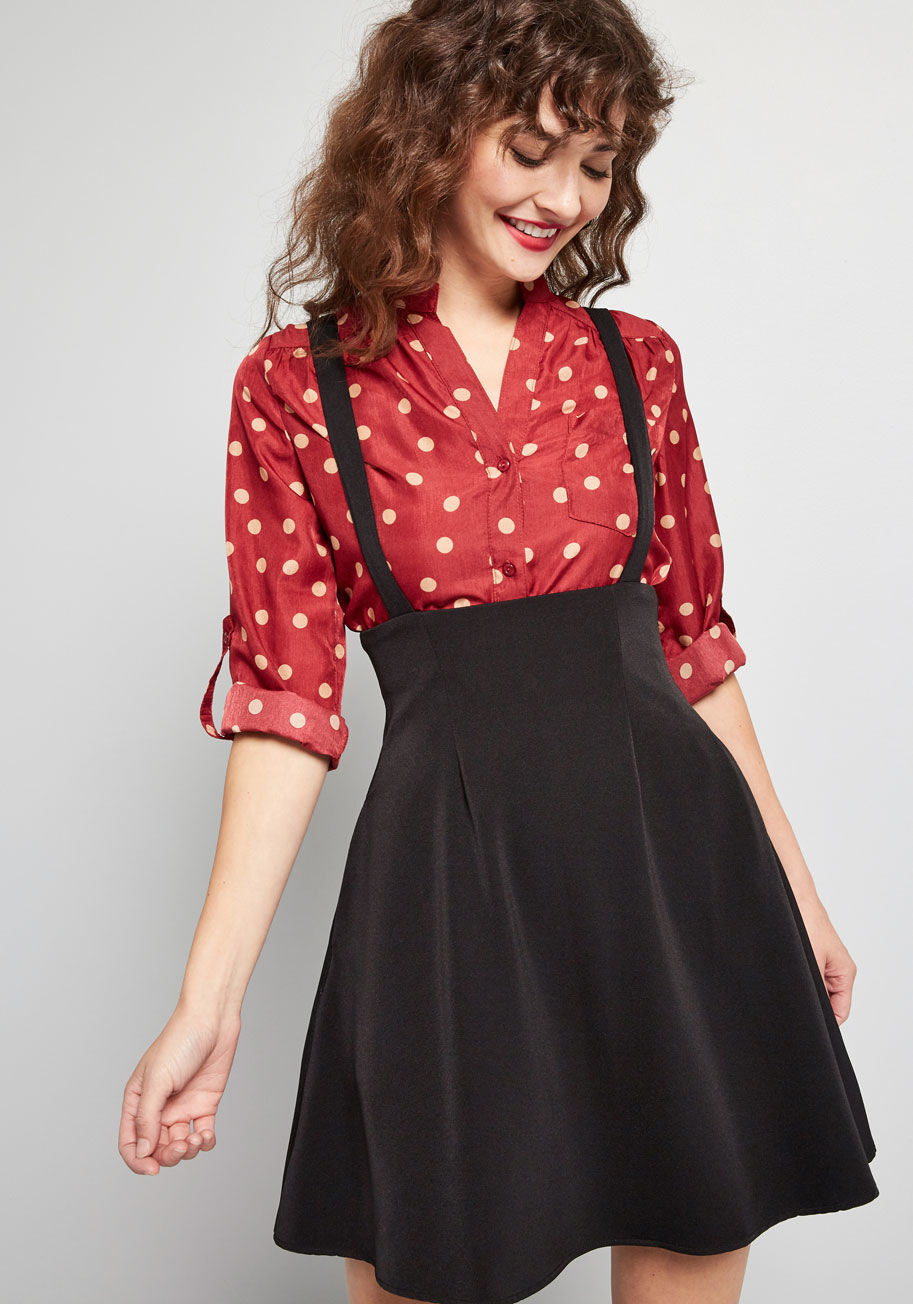 a model wearing the black skater skirt with suspenders attached