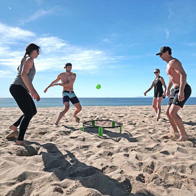 Four people playing the game at the beach