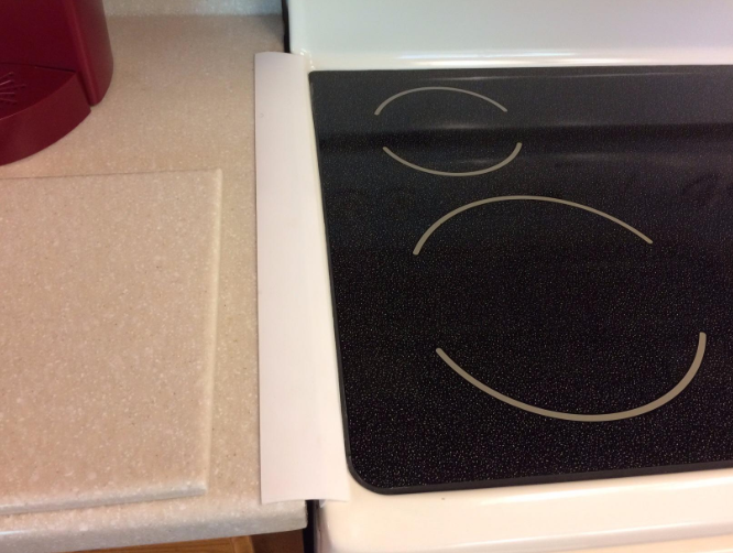A reviewer&#x27;s kitchen showing the gap between the counter and the oven covered with the product