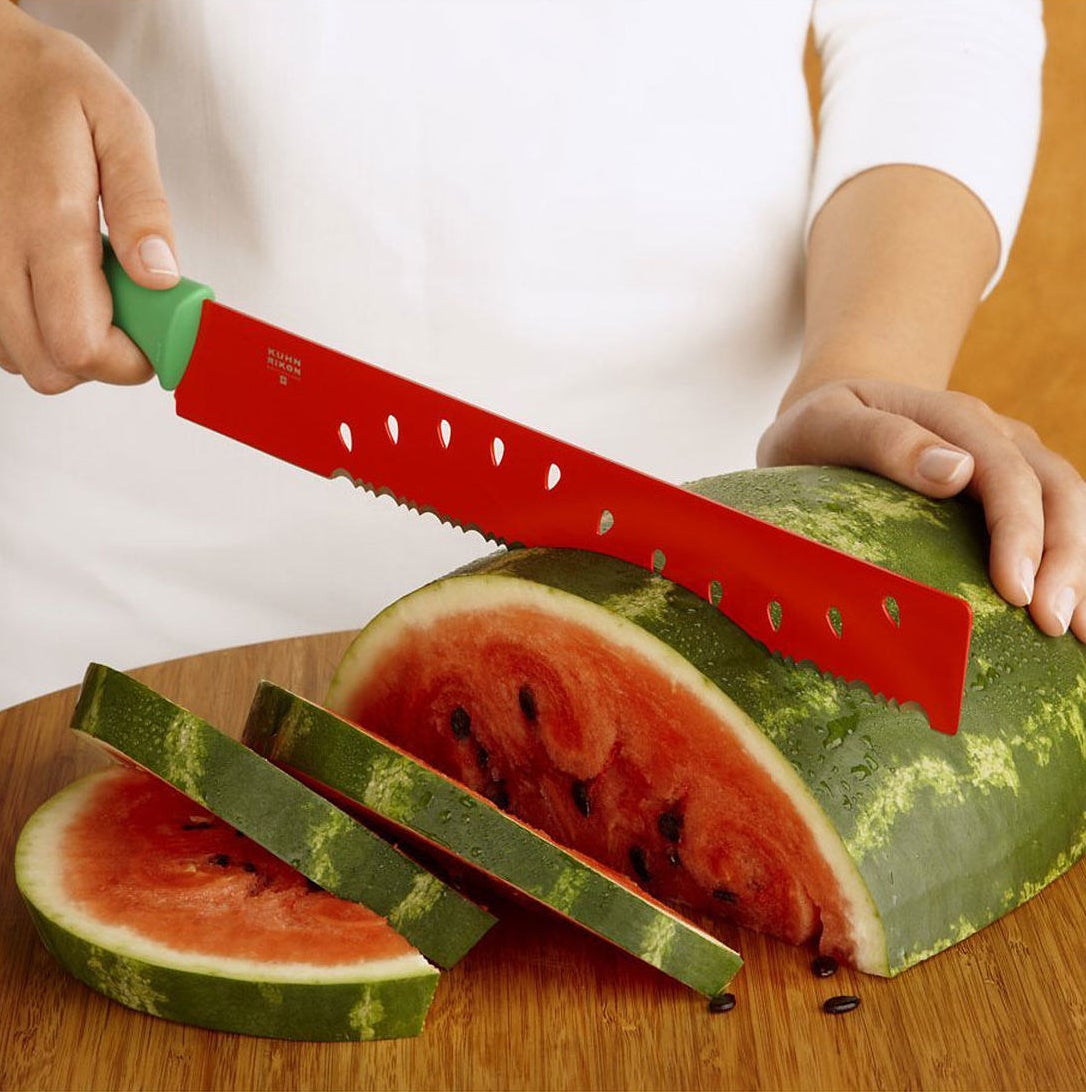 A model slices watermelon with the green-handled, red-bladed serrated knife