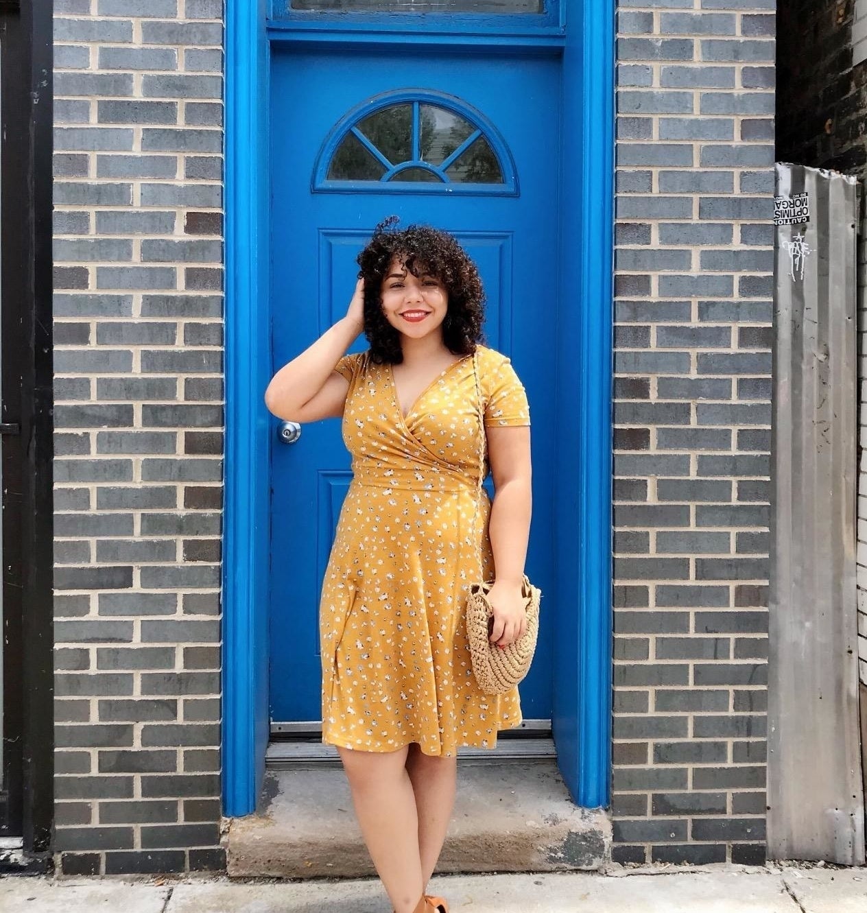 Reviewer wearing the dress in a yellow floral pattern
