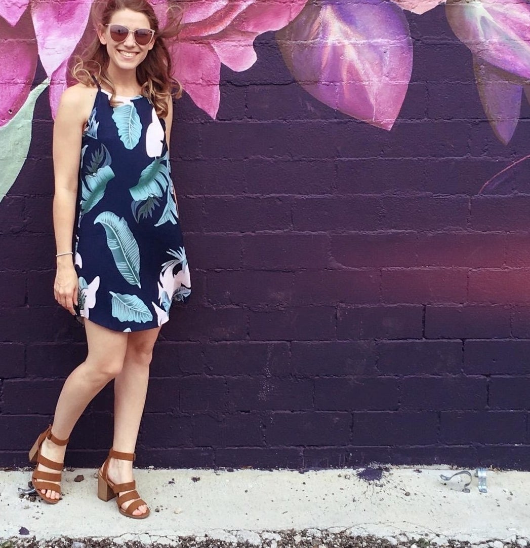 Reviewer wearing the sleeveless dress in tropical design