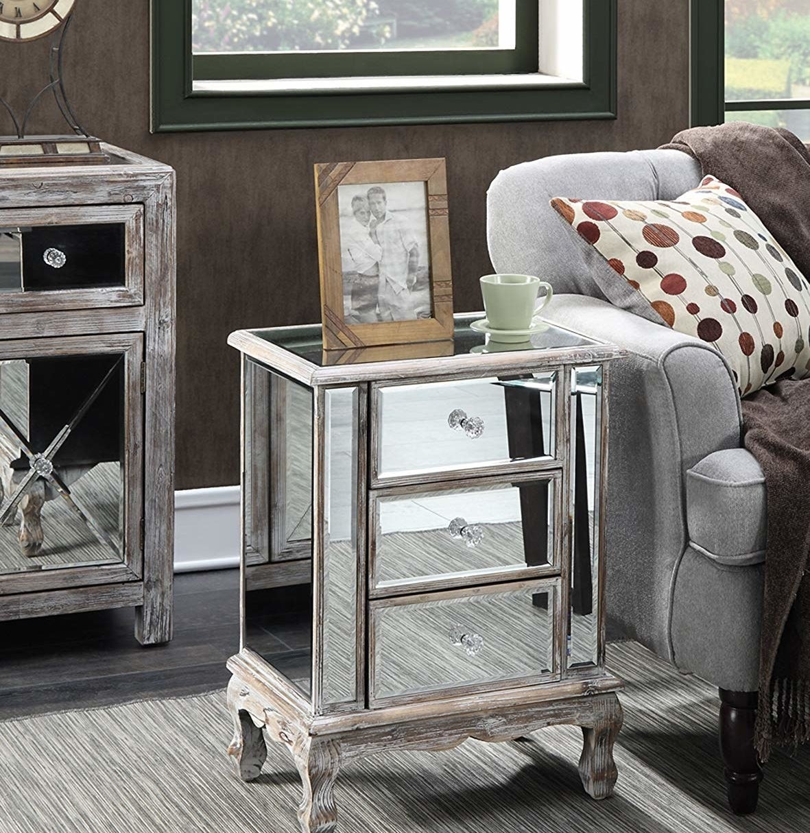 The mirrored end table with three shelves, crystal knobs, and wooden legs