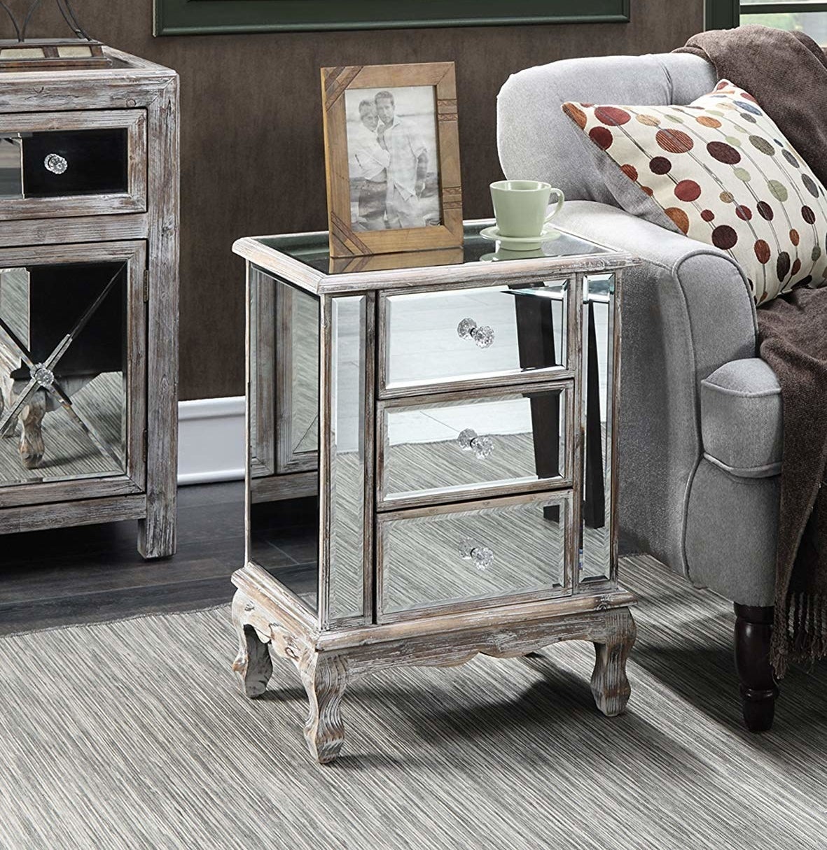 The mirrored end table with three shelves, crystal knobs, and wooden legs