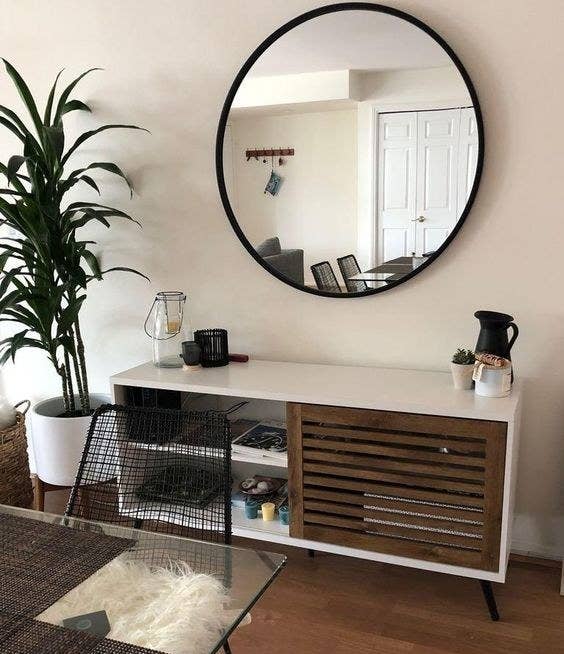 The large round mirror with black framing