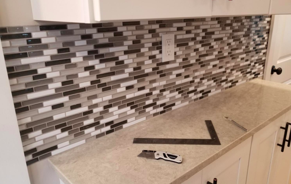 A customer review photo of the installation process for the peel-and-stick tile backsplash
