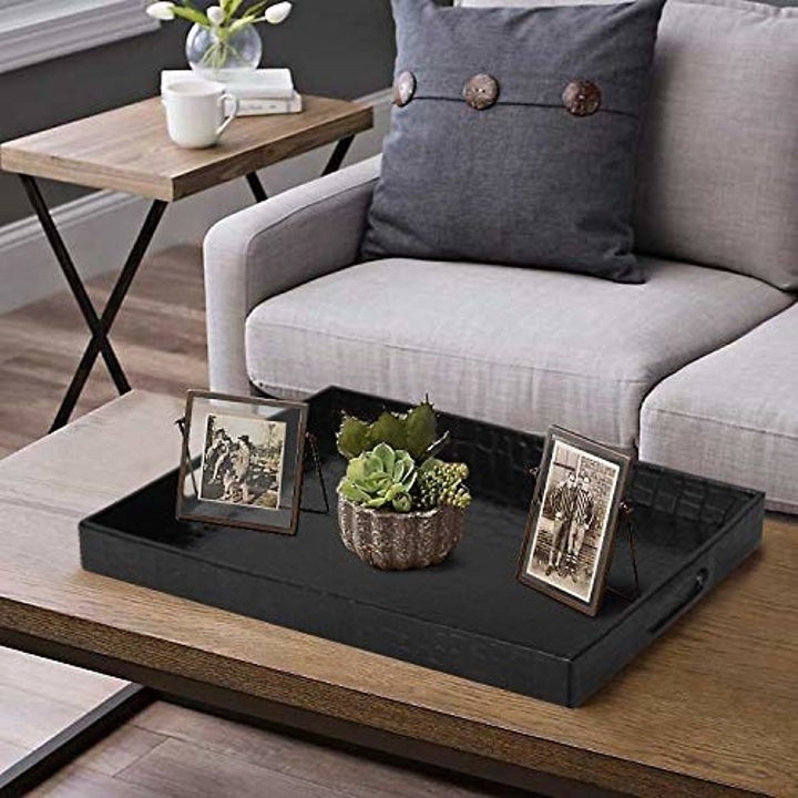 The decorative tray on a table with decor neatly arranged on top of it