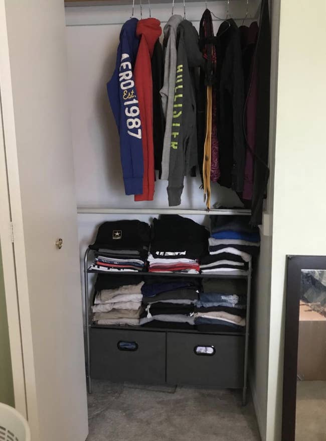 Reviewer photo of the organizer in a closet with lots of t-shirts folded and stacked on the two shelves