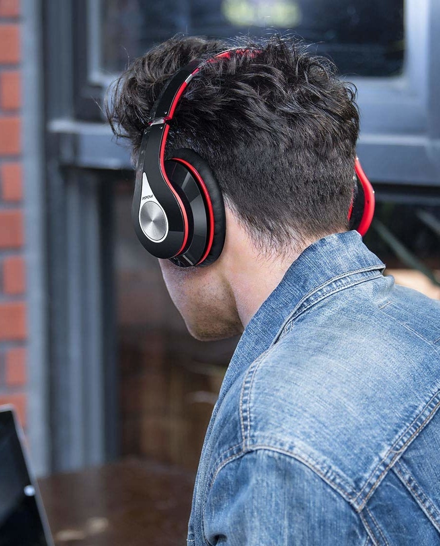A model wearing the headphones in black and red