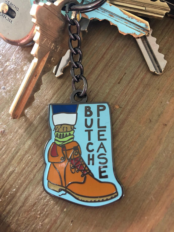 a blue keychain with a boot on it that reads &quot;Butch Please&quot;