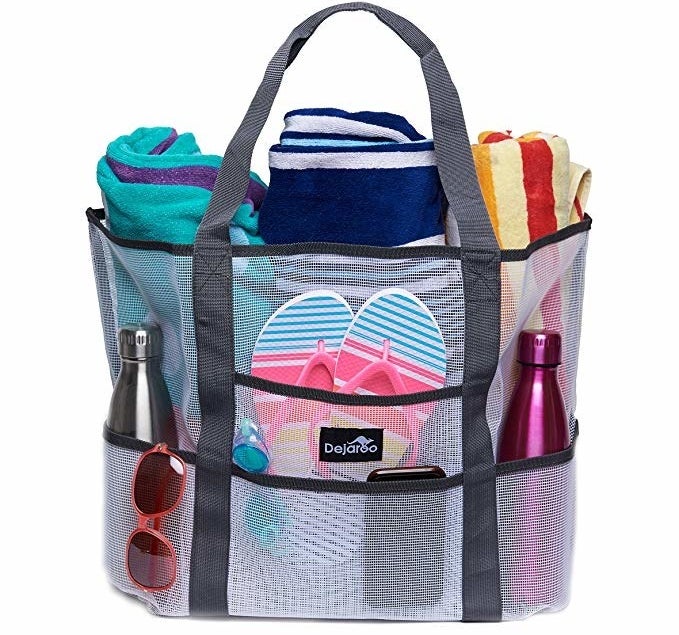 The tote holding flip-flops, two water bottles, sunglasses, three towels, and other items