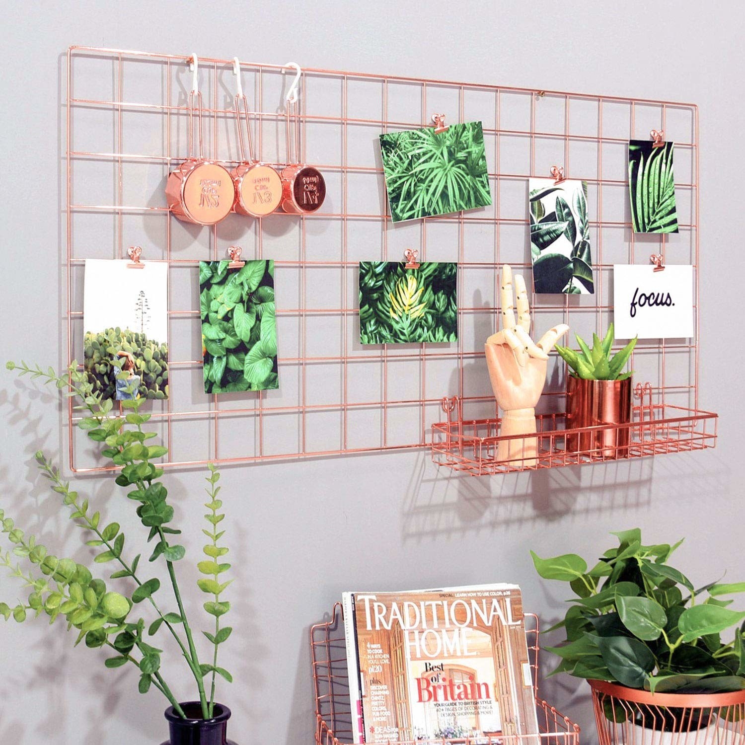 Metal grid hanging on wall. It has matching clips, and a little shelf. 