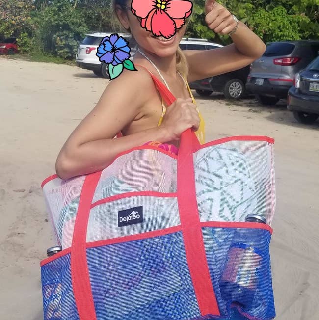 reviewer holding pink white and blue beach bag made of mesh
