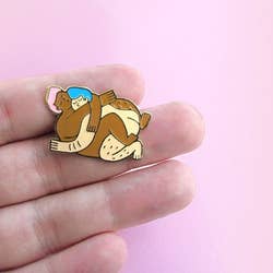 a pin of a queer couple embracing