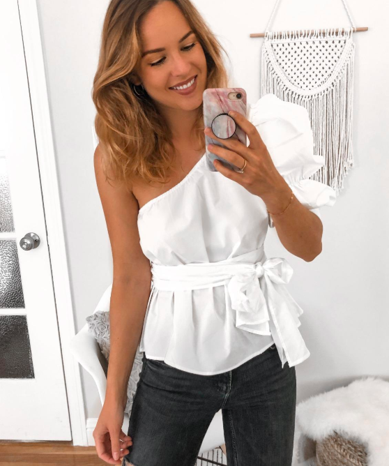 reviewer wearing white one-shoulder top