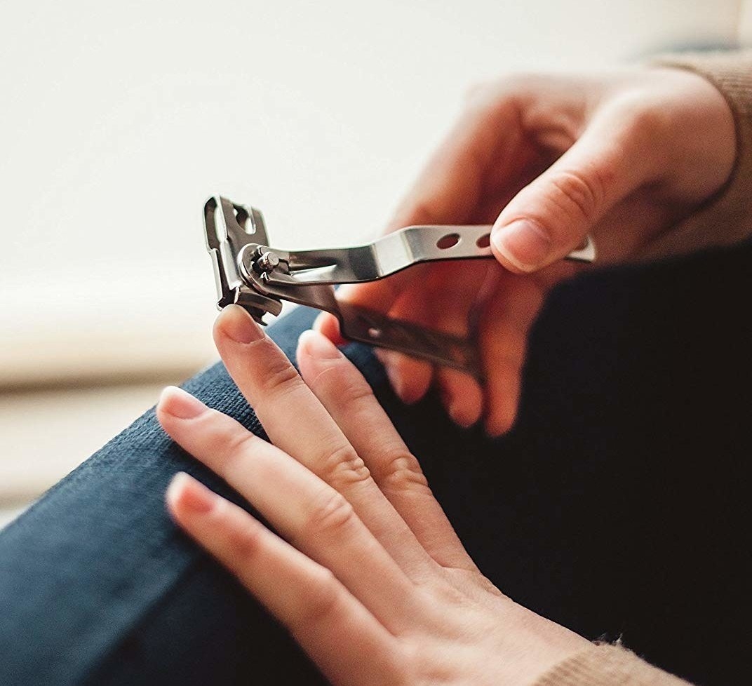 Model using the swivel nail clippers with the handle on the side to show how easy they are to use