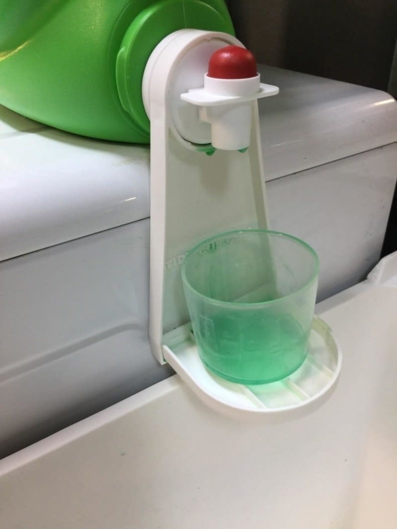 Reviewer photo of the Tidy Cup attached to laundry detergent bottle