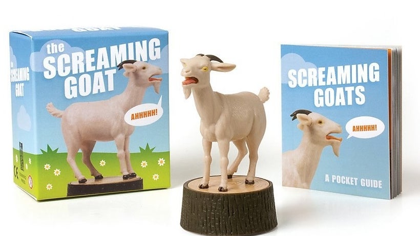 Screaming goat figurine next to box and mini booklet