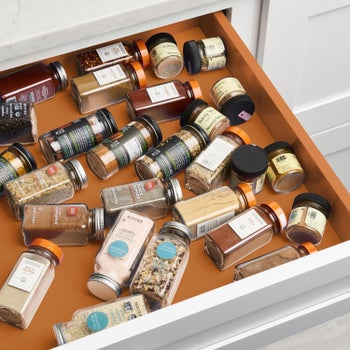 A drawer with scattered spice bottles on their sides