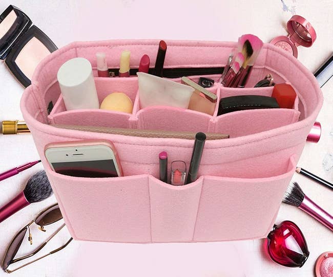 The organizer filled with items, including makeup brushes, phone, beauty products, and more