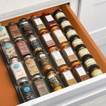 The same drawer, with the spice bottles neatly lined up in the organizer with the labels up