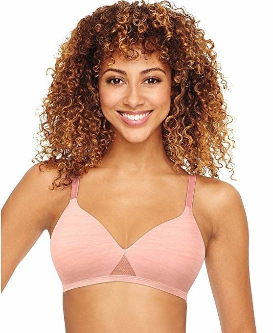 Model wearing the bra, which has a mesh triangle in the center, in pink