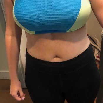 A reviewer wearing a blue and lime green bra with black leggings