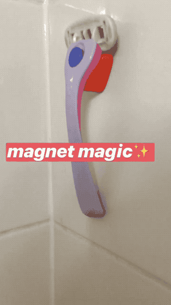 Razor with magnetic holder attached to a tiled wall, labeled 'magnet magic' with star emojis