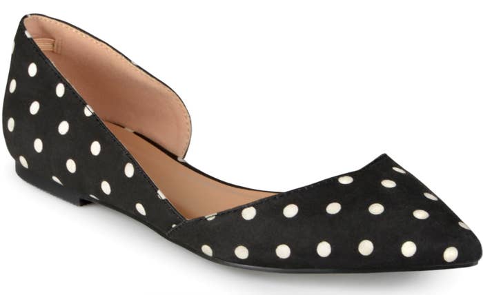 A black cut-out, pointed-toe flat with white polka dots