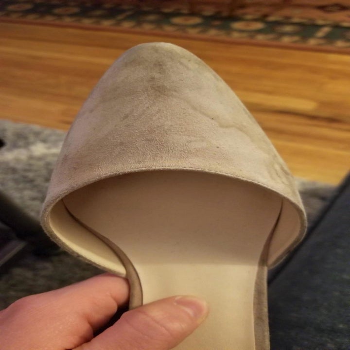 A reviewer's tan suede pump with water stains all over the toes